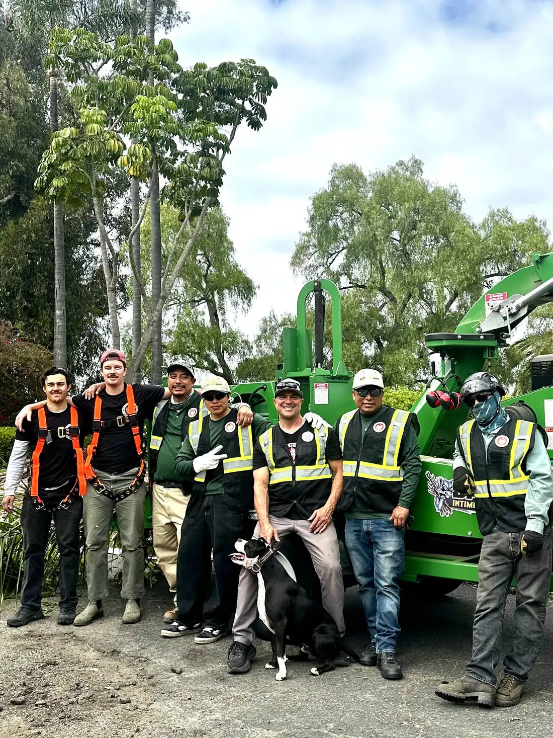 The Garden Works crew in safety gear with their wood chipper, ready for tree work